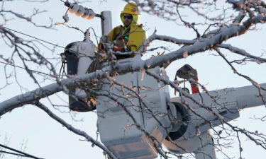 A lineman stands in an elevated platform Sunday while repairing damaged power lines in Chatham