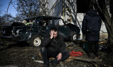 A man sits outside his destroyed building after bombings on the eastern Ukraine town of Chuguiv on February 24.