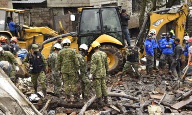 Rescue workers search for survivors after torrential rains triggered a landslide in Quito