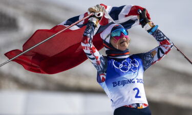 Therese Johaug of Team Norway celebrates winning gold during the Women's Cross-Country Skiing 30k Mass Start Free on Day 16 of the Beijing 2022 Winter Olympics on February 20