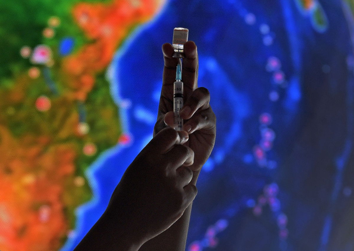 <i>CARL DE SOUZA/AFP/AFP via Getty Images</i><br/>A health worker poses with a syringe with dose of a COVID-19 vaccine at the Museum of Tomorrow where adults and children between the ages of five and eleven are being vaccinated against the novel coronavirus