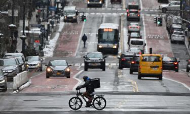 A man on a delivery bike rides in the street after a winter storm hit New York City