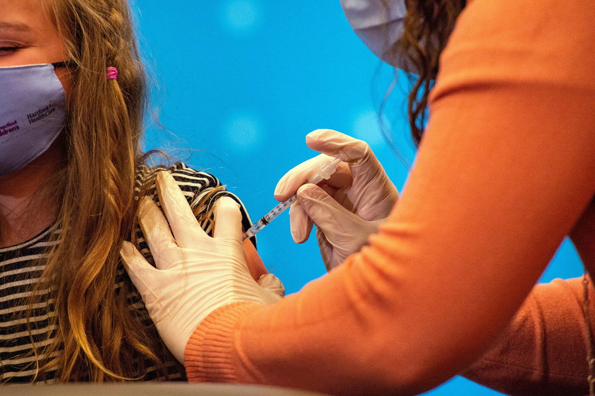 <i>JOSEPH PREZIOSO/AFP/AFP via Getty Images</i><br/>An eight-year-old child receives the Pfizer-BioNTech Covid-19 vaccine for 5 to 11-year-old kids in Hartford