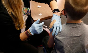 A 8 year-old child receives their first dose of the Pfizer Covid-19 vaccine at the Beaumont Health offices in Southfield