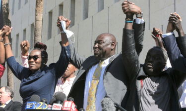 Arbery family attorney Ben Crump (center) clasps hands with Arbery's mother