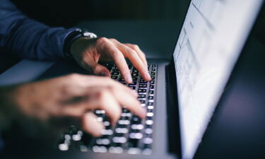 Close up of hands typing on laptop.