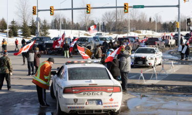 People take part in a protest blocking traffic at the Ambassador Bridge