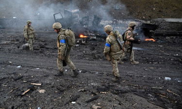 Ukrainian service members collect unexploded shells after a fighting with Russian raiding group in the Ukrainian capital of Kyiv in the morning of February 26