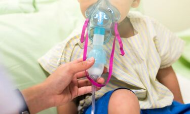 A 3-year-old patient in the hospital receives medication via an inhalation mask to treat Respiratory Syncytial Virus (RSV).