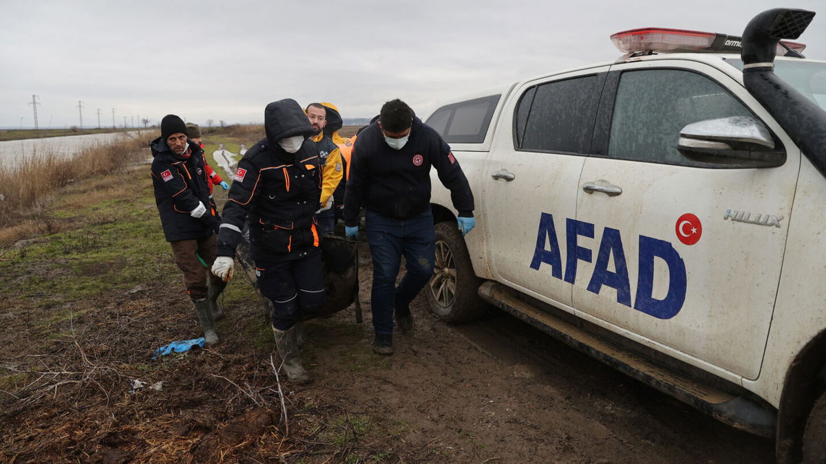 <i>Gokhan Balci/Anadolu Agency via Getty Images</i><br/>Turkish officials carry the bodies of migrants found frozen to death in Ipsala