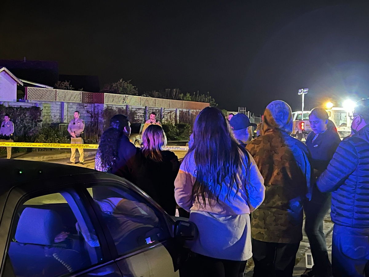 Neighbors watch as investigation is being conducted.