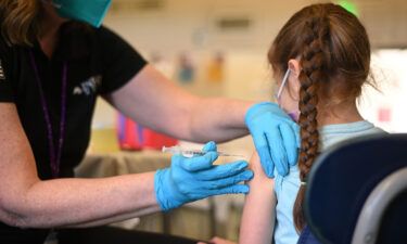 A nurse administers a pediatric dose of the Covid-19 vaccine to a girl in Los Angeles