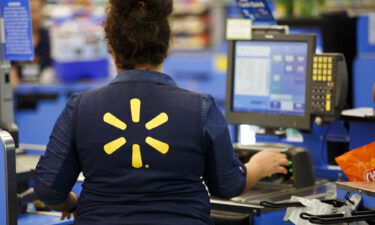 A Walmart employee scans items at a cash register in Burbank
