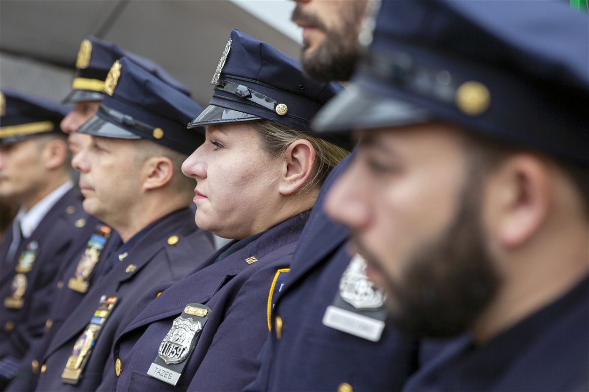 <i>Ted Shaffrey/AP</i><br/>A female police officer stands with her male police department colleagues in New York City.