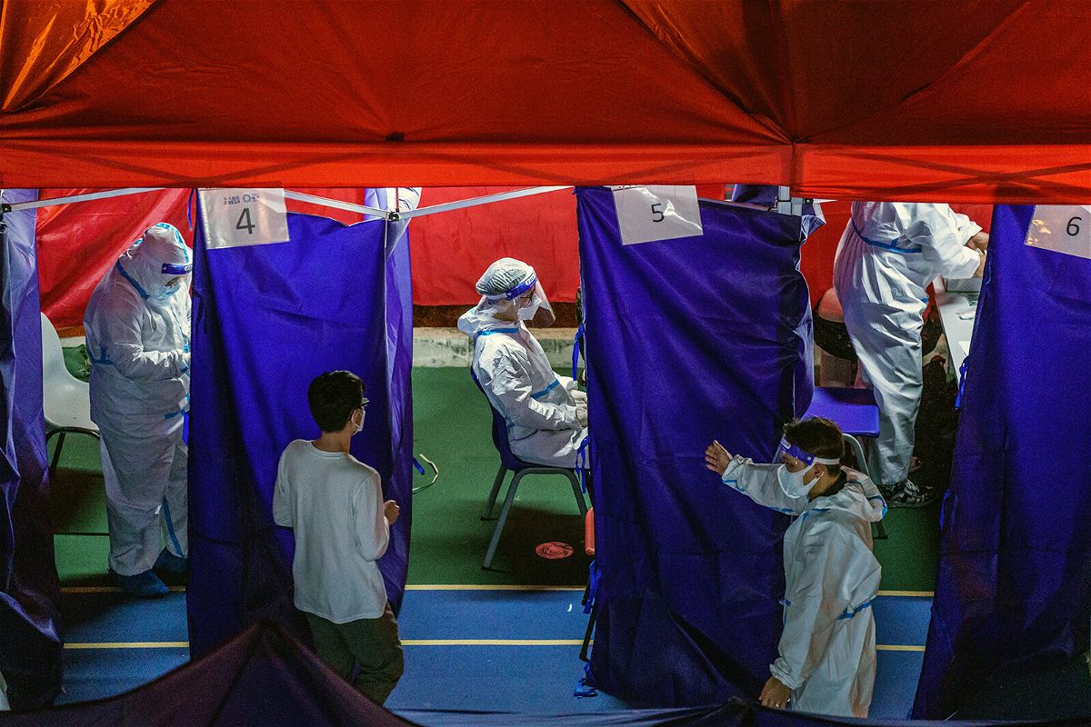 <i>Lam Yik/Bloomberg/Getty Images</i><br/>Healthcare workers attend to patients at a Covid-19 testing site set up outside a residential building placed under lockdown in Hong Kong