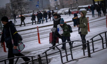 People arrive at a train station as they try to leave Kyiv