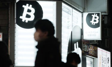 Pedestrians walk past a Sakura Bitcoin Exchange Inc. store in the Shibuya district of Tokyo on Friday