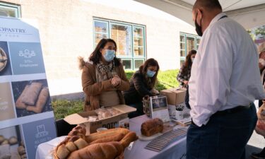 A man speaks with a woman about openings at a bakery during a job fair in Melville