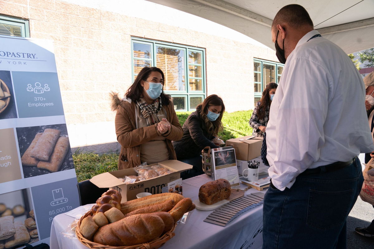 <i>Bryan R. Smith/ AFP/Getty Images</i><br/>A man speaks with a woman about openings at a bakery during a job fair in Melville