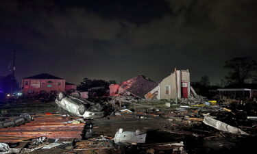 A car lies overturned among debris in Arabi