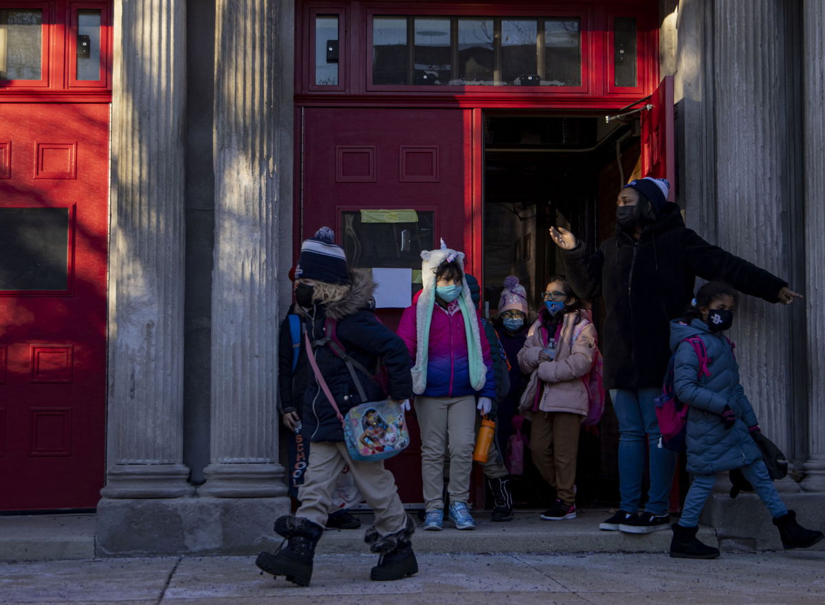 <i>Brian Cassella/Chicago Tribune/Getty Images</i><br/>Student wear masks as they leave a Chicago elementary school on January 3.