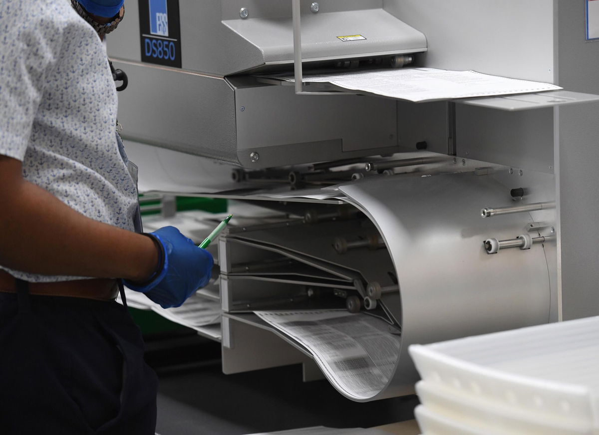 <i>mpi04/MediaPunch/IPX/AP</i><br/>Election workers are seen loading ballots into the vote counting machine on election day 2020 at the Broward County Supervisor of Elections office during the 2020 Presidential Election