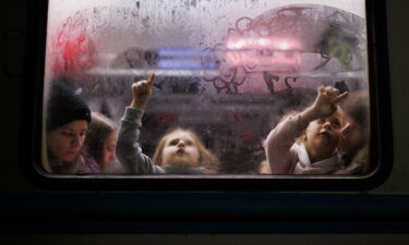 Two girls paint the foggy glass of one of the carriages at the Lviv train station