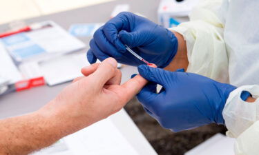 A health worker takes a drop of blood for the Covid-19 antibody test in Torrance