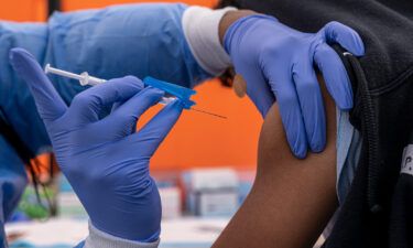A healthcare worker administers a Pfizer-BioNTech Covid-19 vaccine to a child at a testing and vaccination site in San Francisco