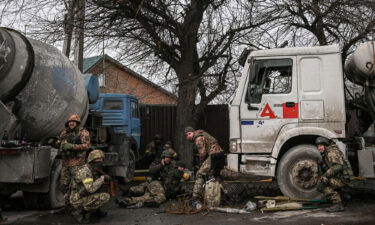 Ukainian service men take cover from shelling in the city of Bucha