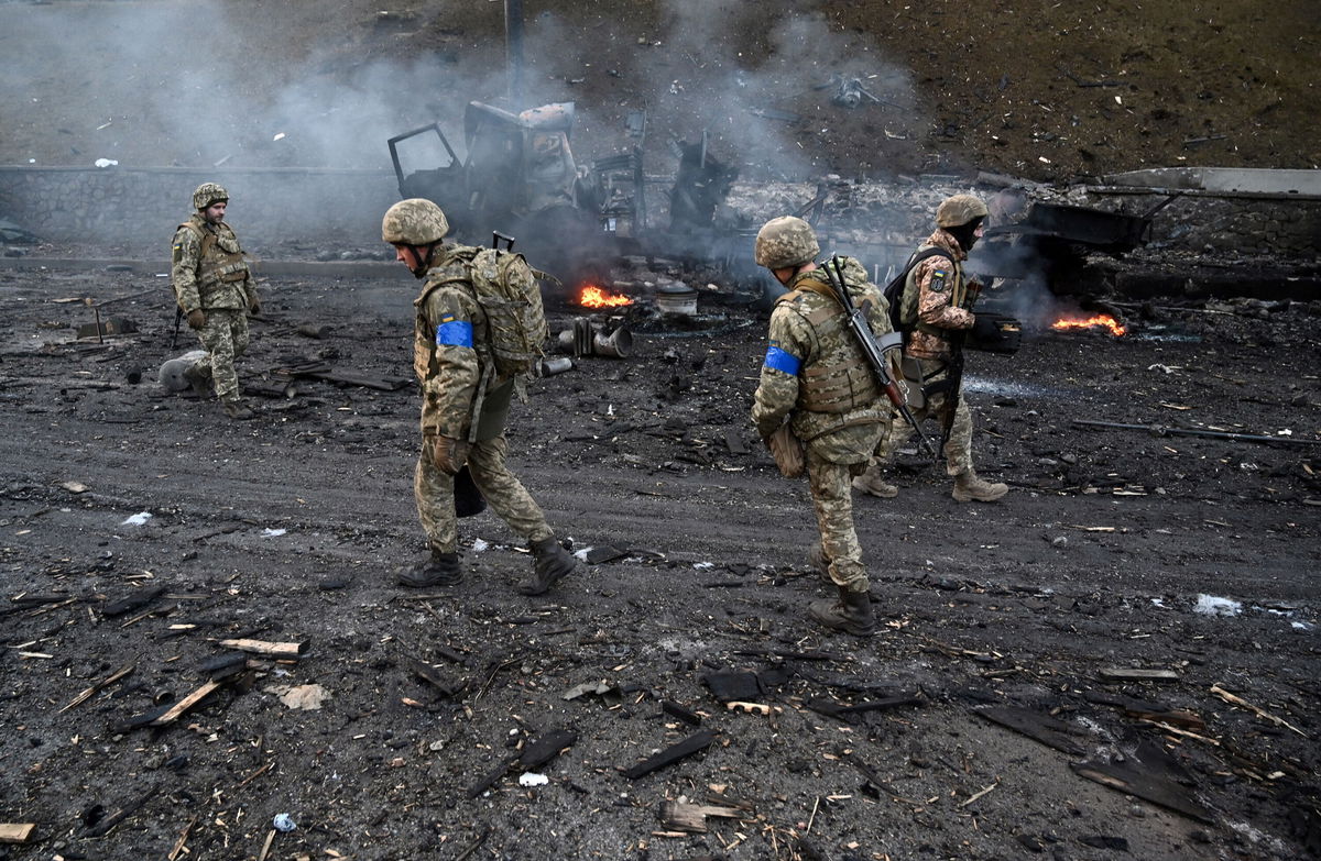 <i>Sergei Supinsky/AFP/Getty Images</i><br/>Ukrainian service members are seen collecting unexploded shells after fighting with a Russian raiding group in Kyiv. Psychologists explain how to talk to your kids about Ukraine.