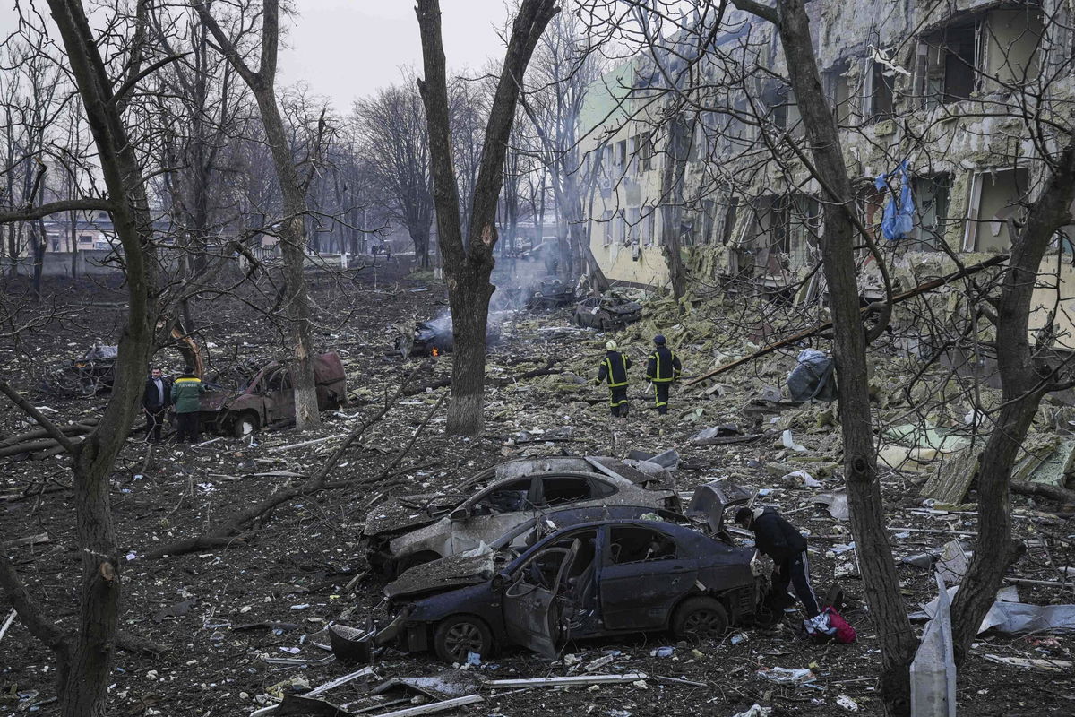 <i>Evgeniy Maloletka/AP</i><br/>Ukrainian emergency employees work at the hospital damaged by shelling in Mariupol.