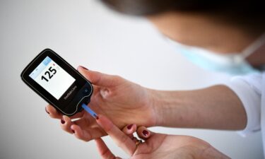 A woman uses a glucometer to measure the glycemia in her blood in Paris