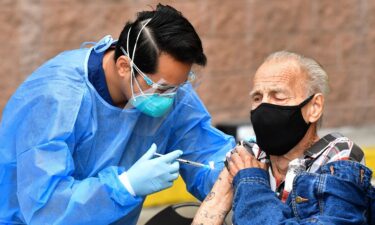 Registered Nurse Angelo Bautista administers the Moderna Covid-19 vaccine during the distribution of vaccines to seniors above the age of 65 who are experiencing homelessness at the Los Angeles Mission.