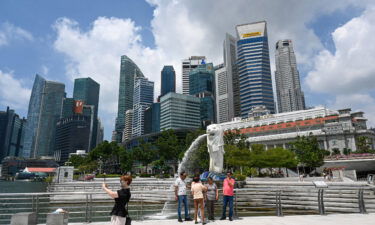 People take pictures in front of the Merlion statue in Singapore on March 24.