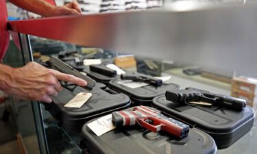 A worker restocks handguns in Orem