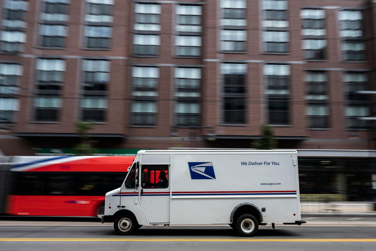 A postman drives a United States Postal service (USPS) mail delivery truck through Washington, DC on August 13, 2021. (Photo by ANDREW CABALLERO-REYNOLDS / AFP) (Photo by ANDREW CABALLERO-REYNOLDS/AFP via Getty Images)