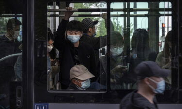 People wear protective masks as they ride on a public bus during evening rush hour  in the Central Business District on April 21