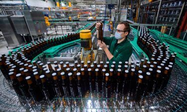 An employee inspects a bottle at a brewery bottling plant in the German state of North Rhine-Westphalia.