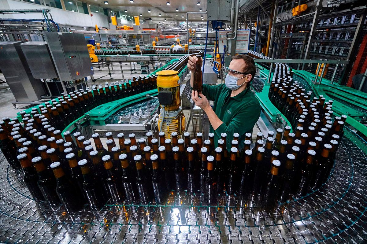 <i>Bernd Thissen/DPA/AP</i><br/>An employee inspects a bottle at a brewery bottling plant in the German state of North Rhine-Westphalia.