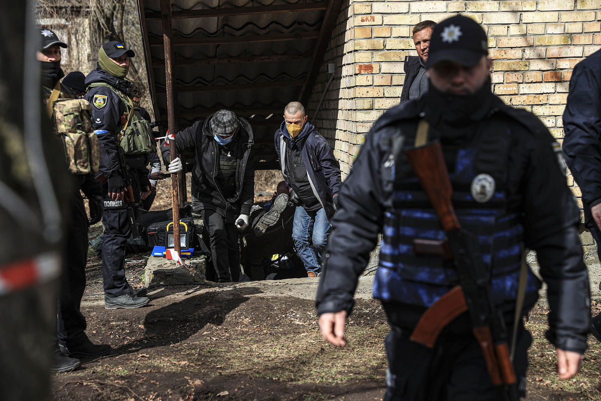 <i>Metin Aktas/Anadolu Agency/Getty Images</i><br/>Bodies are gathered for burial in Bucha on Monday.