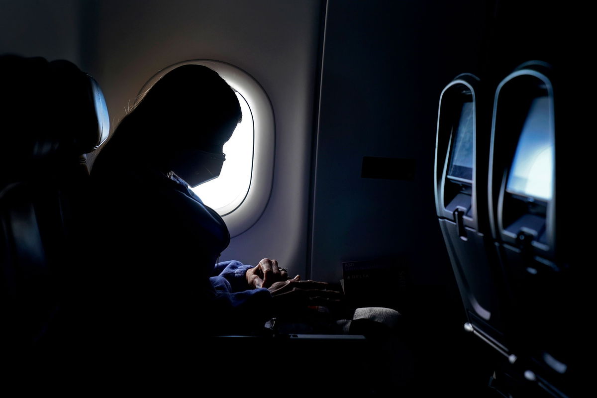 <i>Charlie Riedel/AP</i><br/>A passenger wears a face mask as she travels on a flight from Hartsfield-Jackson International Airport in Atlanta.