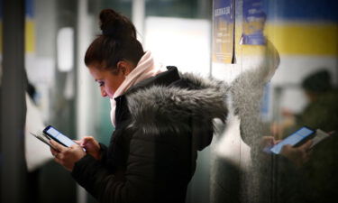 A woman uses a mobile phone at the Warsaw East railway station in Warsaw