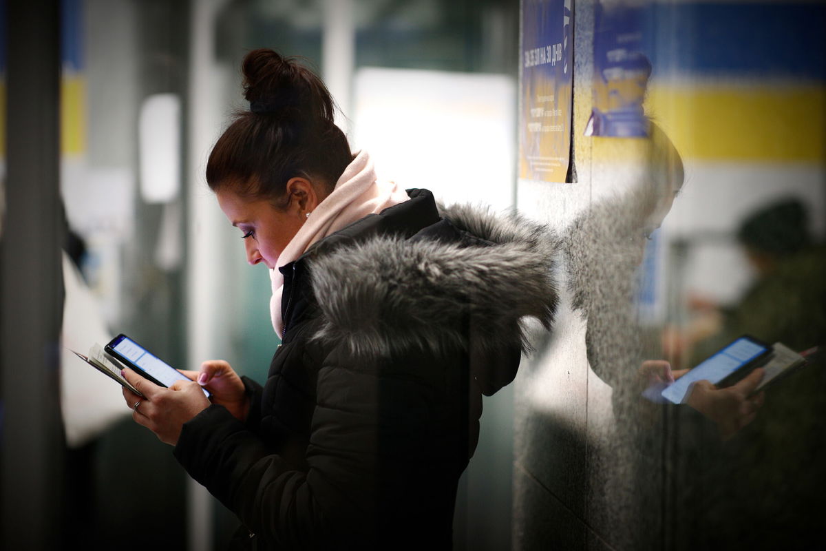 <i>NurPhoto/Getty Images</i><br/>A woman uses a mobile phone at the Warsaw East railway station in Warsaw