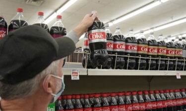 A shopper takes a bottle of Diet Coke from a store in Orem