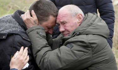 Relatives cry at the mass grave of civilians killed during the Russian occupation in Bucha