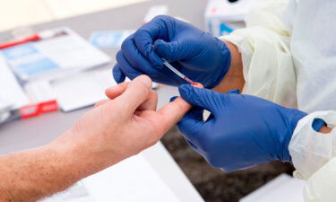 A health worker takes a drop of blood for an antibody test at the Diagnostic and Wellness Center on May 5