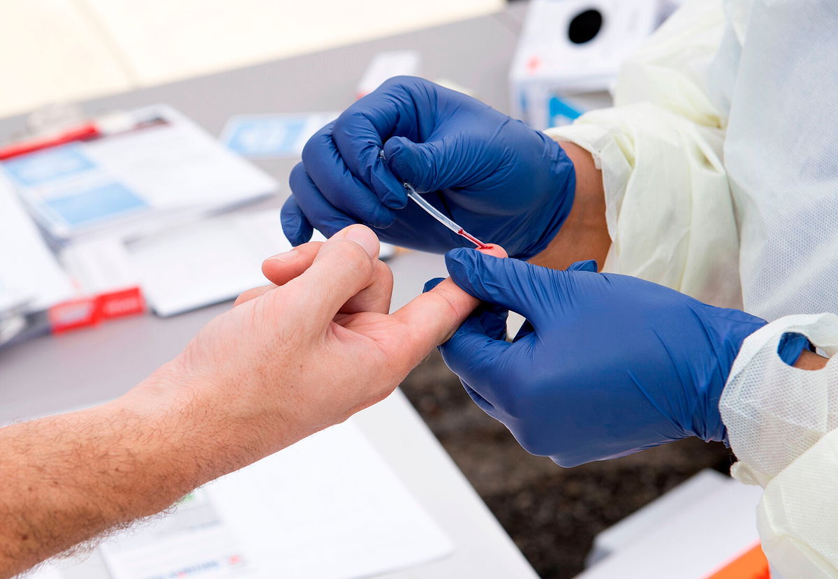 <i>Valerie Macon/AFP/Getty Images</i><br/>A health worker takes a drop of blood for an antibody test at the Diagnostic and Wellness Center on May 5