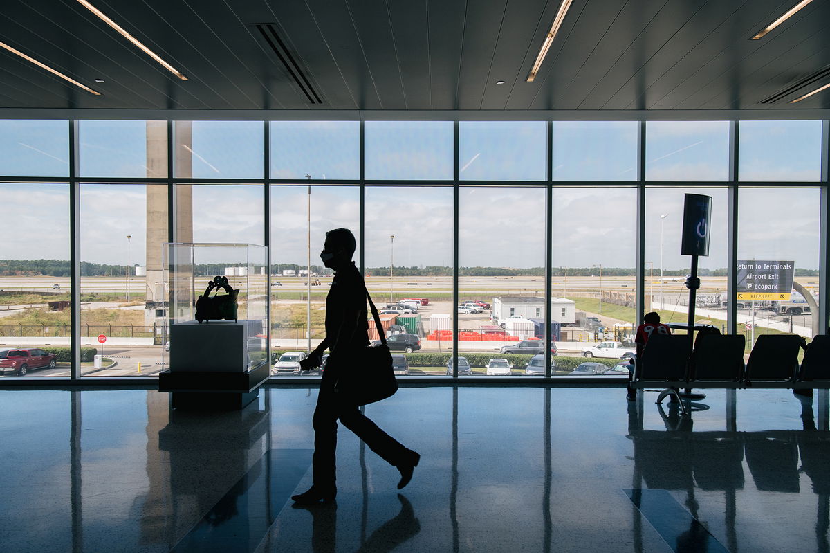 HOUSTON, TEXAS - DECEMBER 03: A traveller walks through the George Bush Intercontinental Airport on December 03, 2021 in Houston, Texas. Many countries have tightened travel restrictions after it was announced the discovery of a new COVID-19 variant, named Omicron. On November 25. U.S. President Joe Biden reinforced travel mandates and required all inbound international travelers to be tested within one day of departure for the United States. Biden also announced that the federal mask mandate requiring travelers to wear masks in airports, on planes, and on other modes of public transportation such as trains and buses has been extended through March 18. The travel bans announced on November 26 prohibit entry into the U.S. of non-citizens coming from eight countries in southern Africa. (Photo by Brandon Bell/Getty Images)