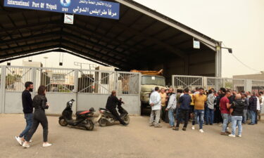 Relatives of those who died when a boat capsized coast gather at the port of Tripoli